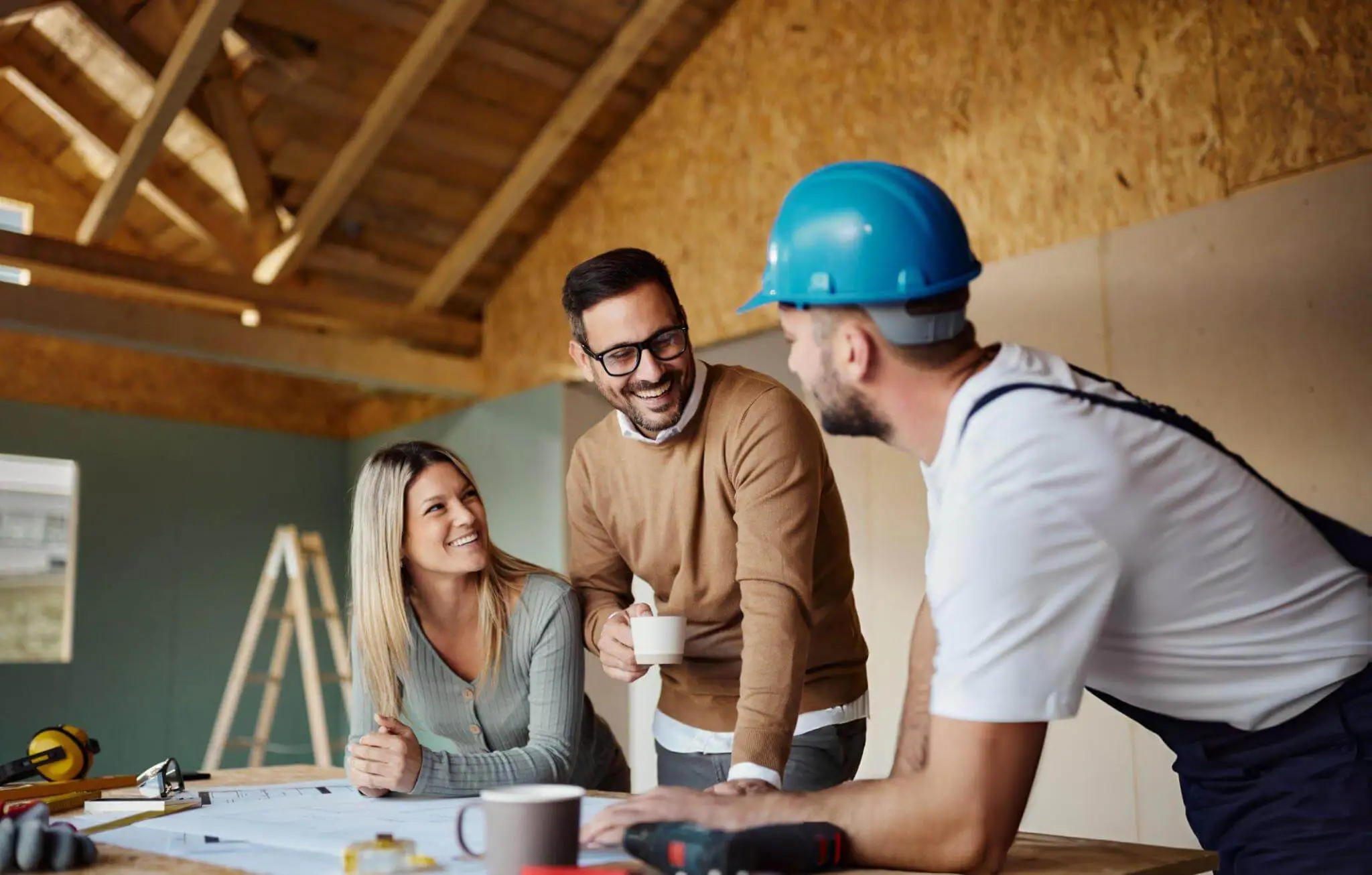 Homeowners discussing installation plans with a contractor inside an under-construction home