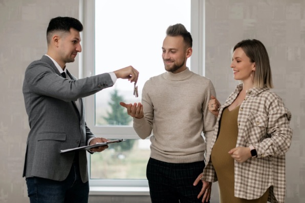 Landlord handing over keys to a couple in their new rental home