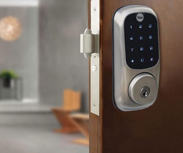 Yale smart lock with a touchscreen keypad installed on a wooden front door