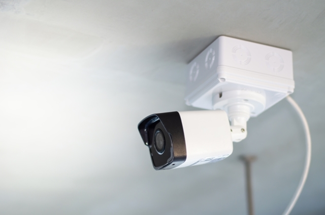 How to Power Outdoor Security Camera: Wired security cameras mounted on the top corner of a building, strategically placed to monitor the area for enhanced security.